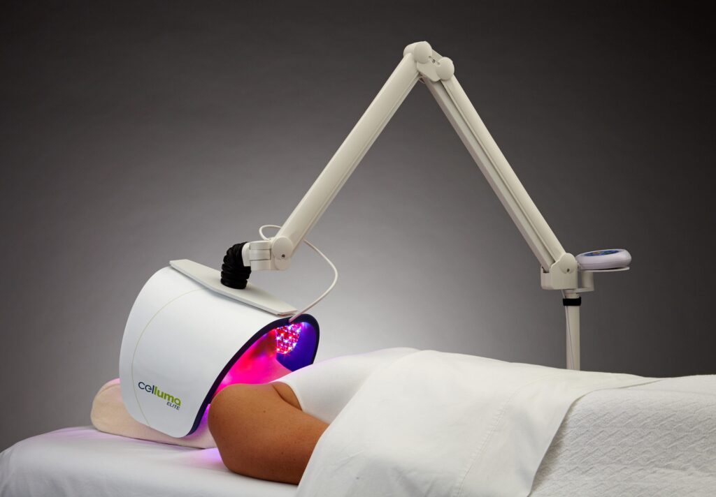 Person receiving red and purple light therapy treatment from a Celluma Elite device.