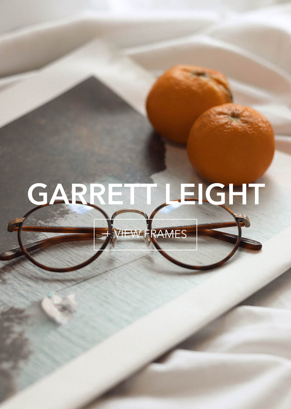 glco-final2_3 Round tortoise-shell eyeglasses on a magazine, with two oranges on a crumpled white sheet.
